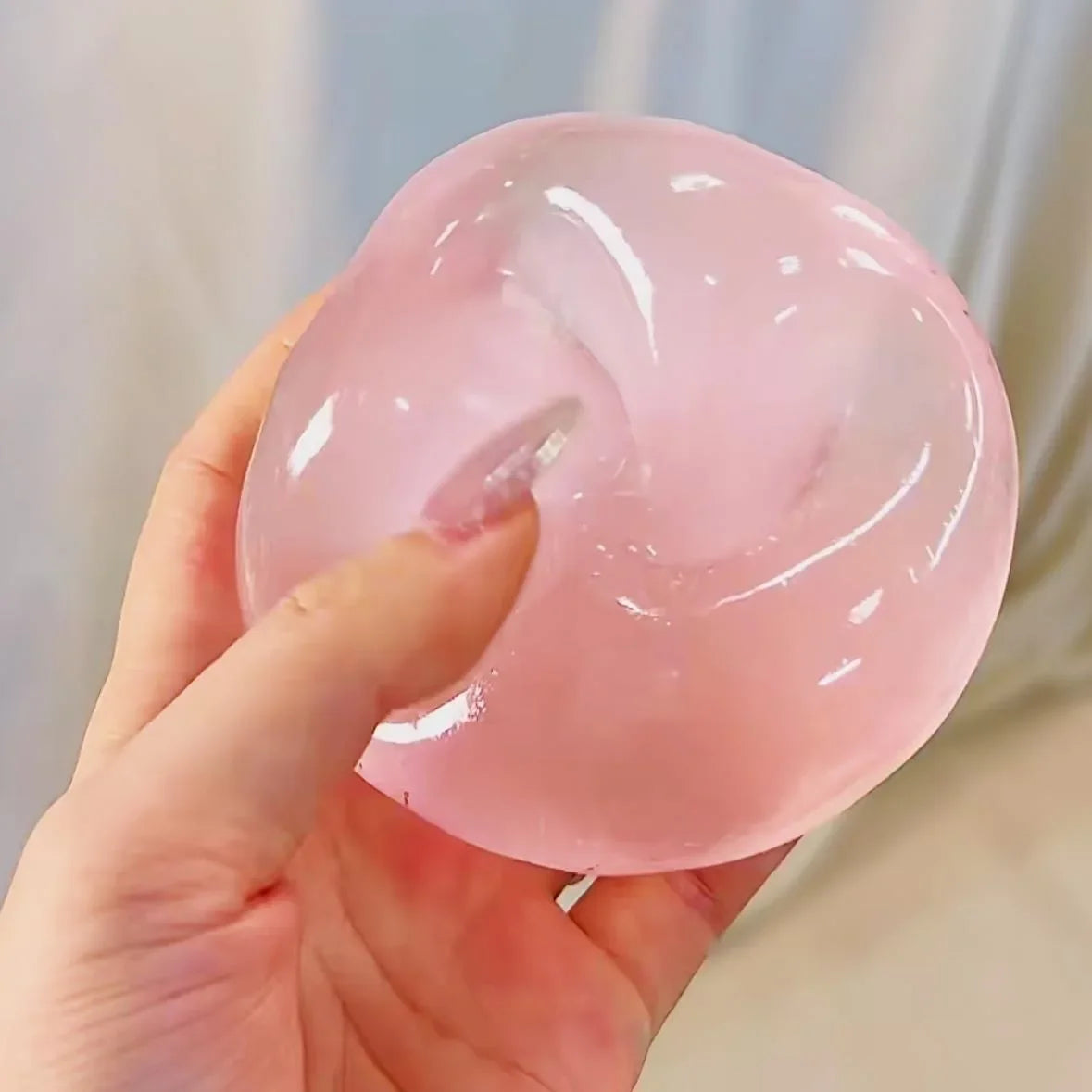 Pink squishy stress ball being squeezed