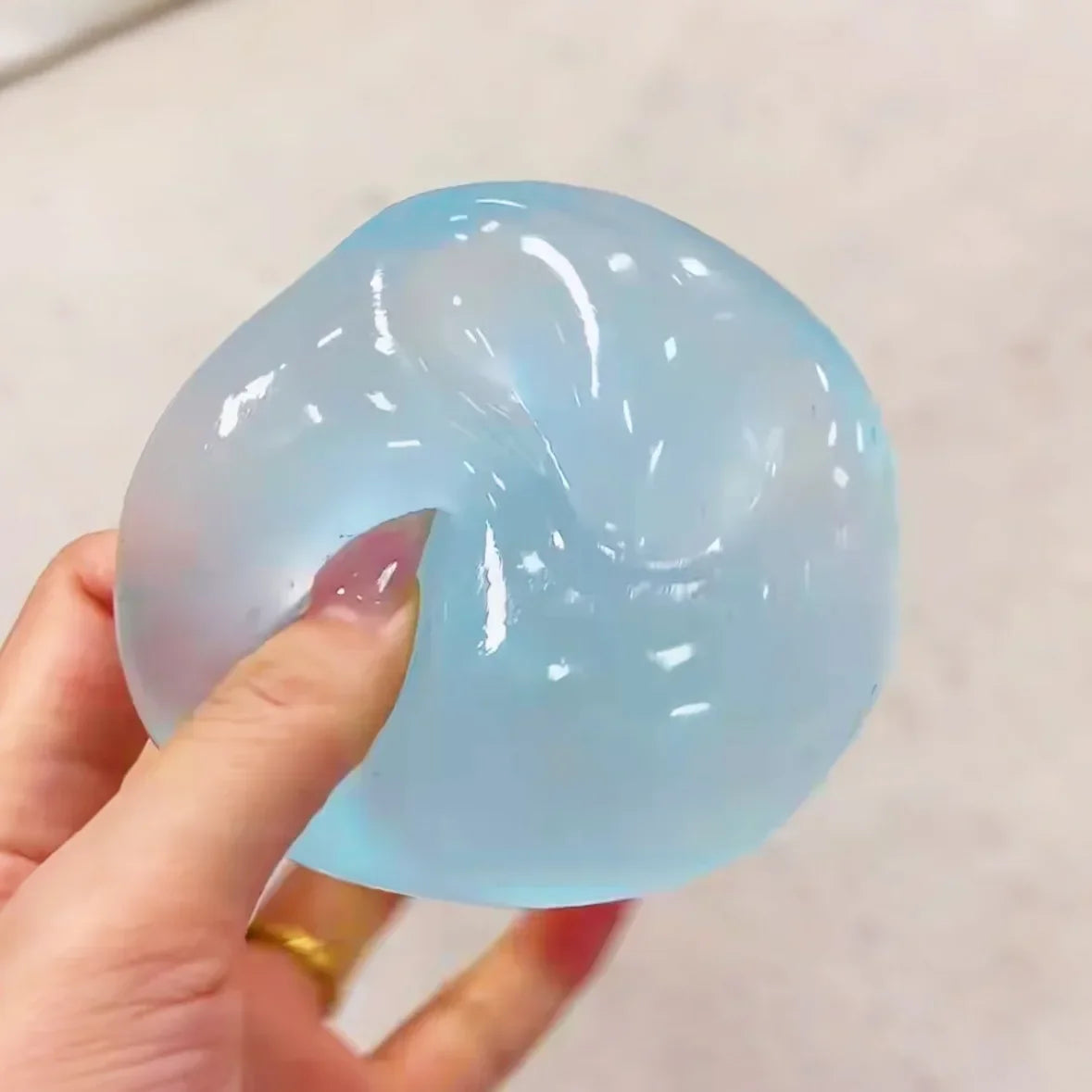 Squeezing the blue squishy gel stress ball